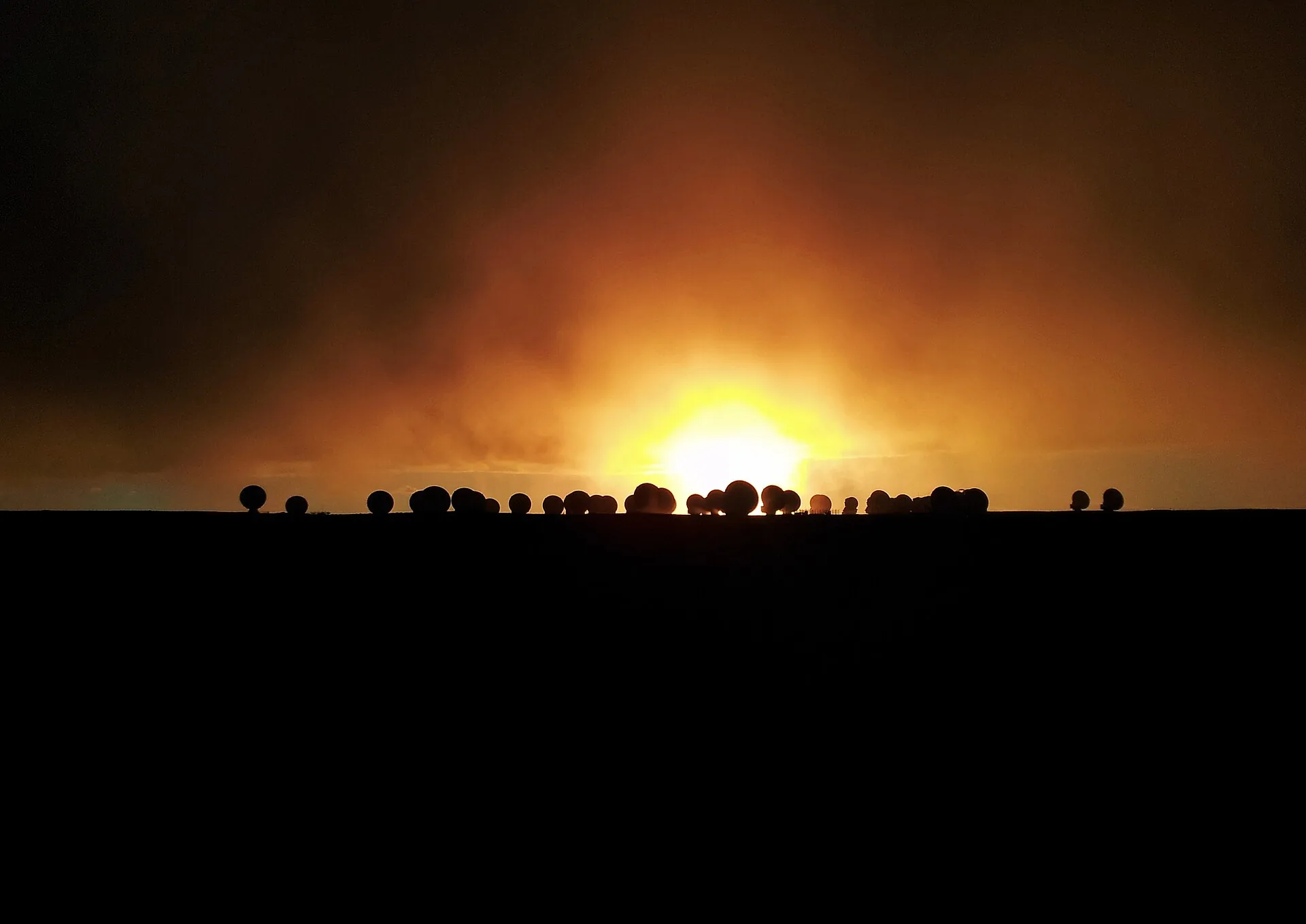 Sol rojizo sobre el horizonte de una meseta andina al anochecer