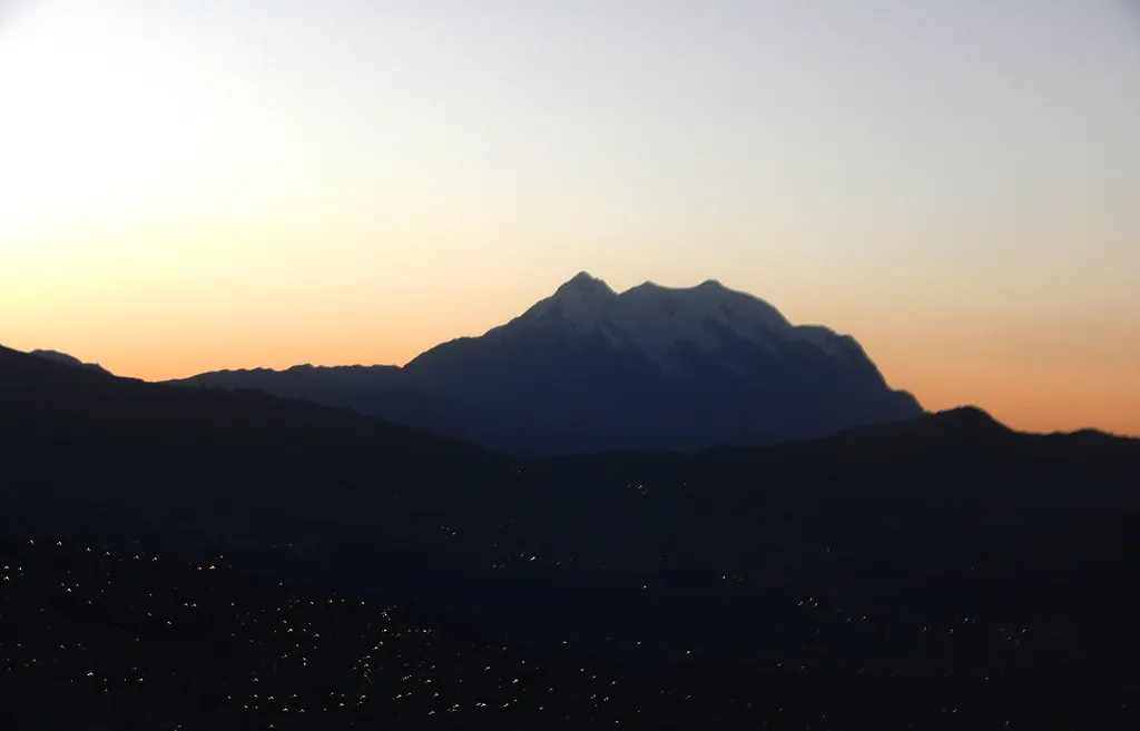 Silueta de una montaña contra el cielo anaranjado del atardecer, vista desde La Paz